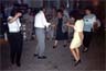 Χορός στην πλατεία των Μιστεγνών Λέσβου στο πανηγύρι των Αγίων Ακινδύνων, στις 23/05/1997. Διακρίνονται μέλη της κομπανίας του Απόστολου Μπόνη: Νίκος Χριστιανός (βιολί), Απόστολος Μπόνης (μπουζούκι).