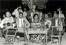 Σε καφενείο στις Καρυές Χίου, το 1955. Διακρίνονται οι μουσικοί από αριστερά προς τα δεξιά: Οδυσσέας Γκιουλμπαξιώτης (βιολί), Στέφανος Νεαμονιτάκης (κλαρίνο), τραγουδίστρια (η σύζυγος του Κώστα Μπούρα), Ηλίας Εγγλέζος (ούτι, τραγούδι), Κώστας Μπούρας (μπουζούκι), άγνωστος από τη Μυτιλήνη (ακορντεόν).